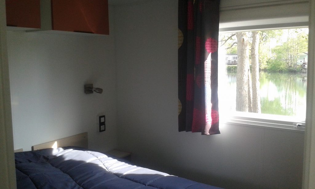 Chambre du mobil-home La Perche avec vue sur l'étang