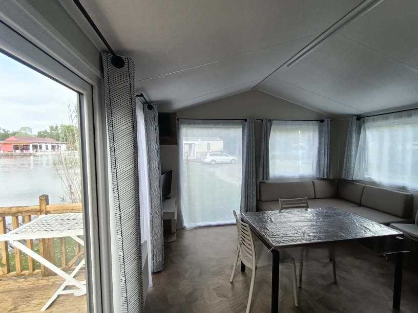 Séjour lumineux du mobil-home Le Brochet avec vue sur l'étang